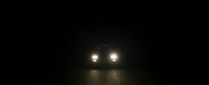 Car headlights shine in the dark.