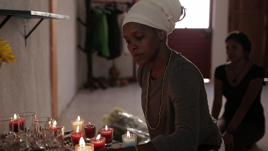 A woman lights red candles.