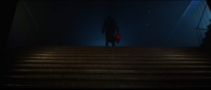 A dark figure stands at the top of a set of stairs.